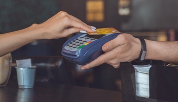 Womans hand holding deit card making contactless card payment