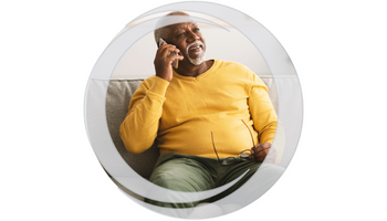 Telephone Banking. African American male senior sitting on couch with phone to ear