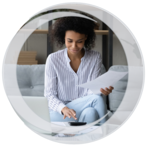 Young adult african american female sitting on couch calculating finances